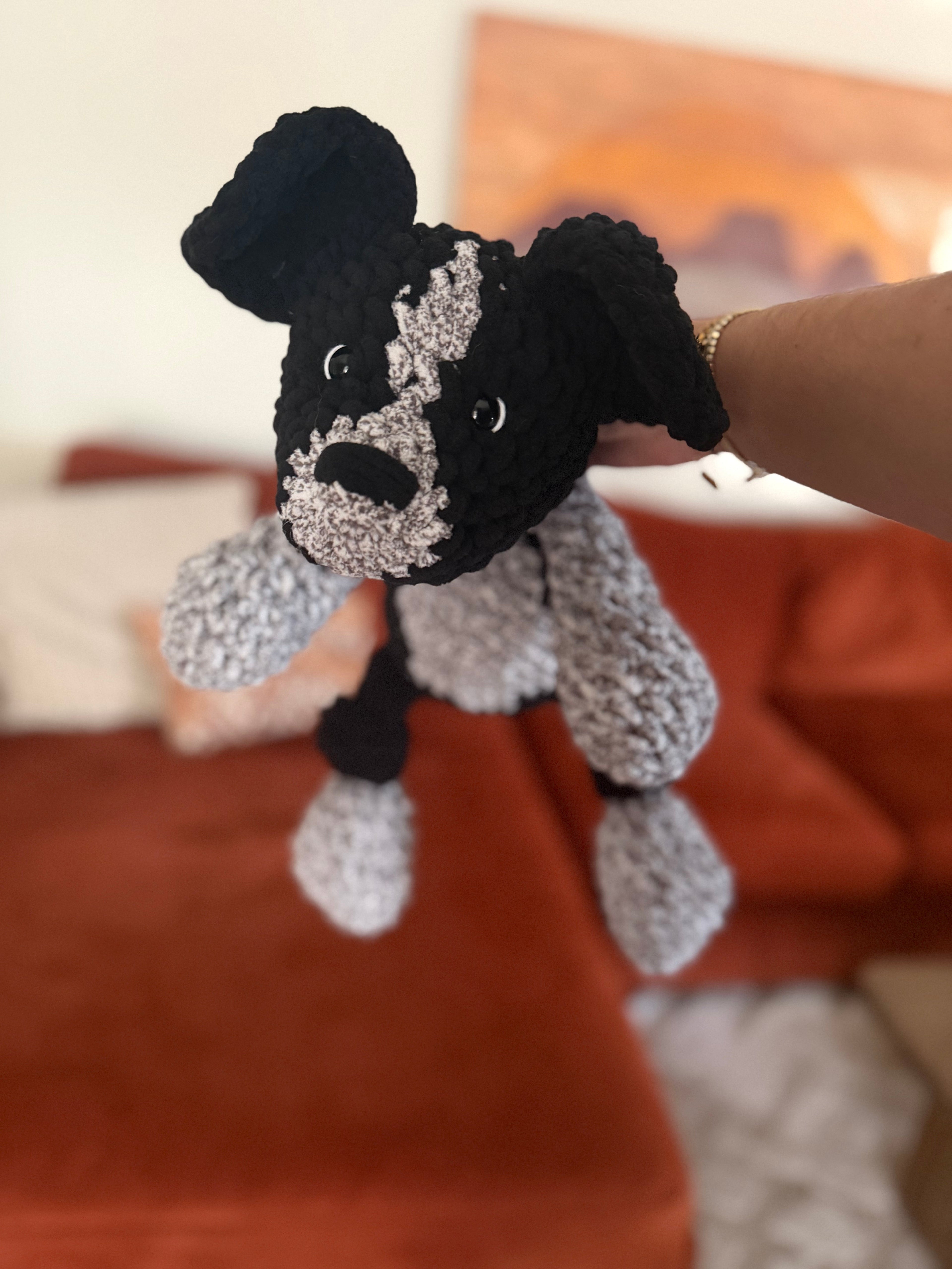 black and white crochet dog in front of blurred orange couch