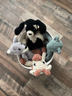 Four crochet animals in a basket on the floor