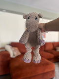 tan and purple crochet hippo in front of blurred orange couch