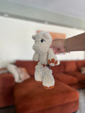 white crochet hippo with orange toes in front of blurred orange couch