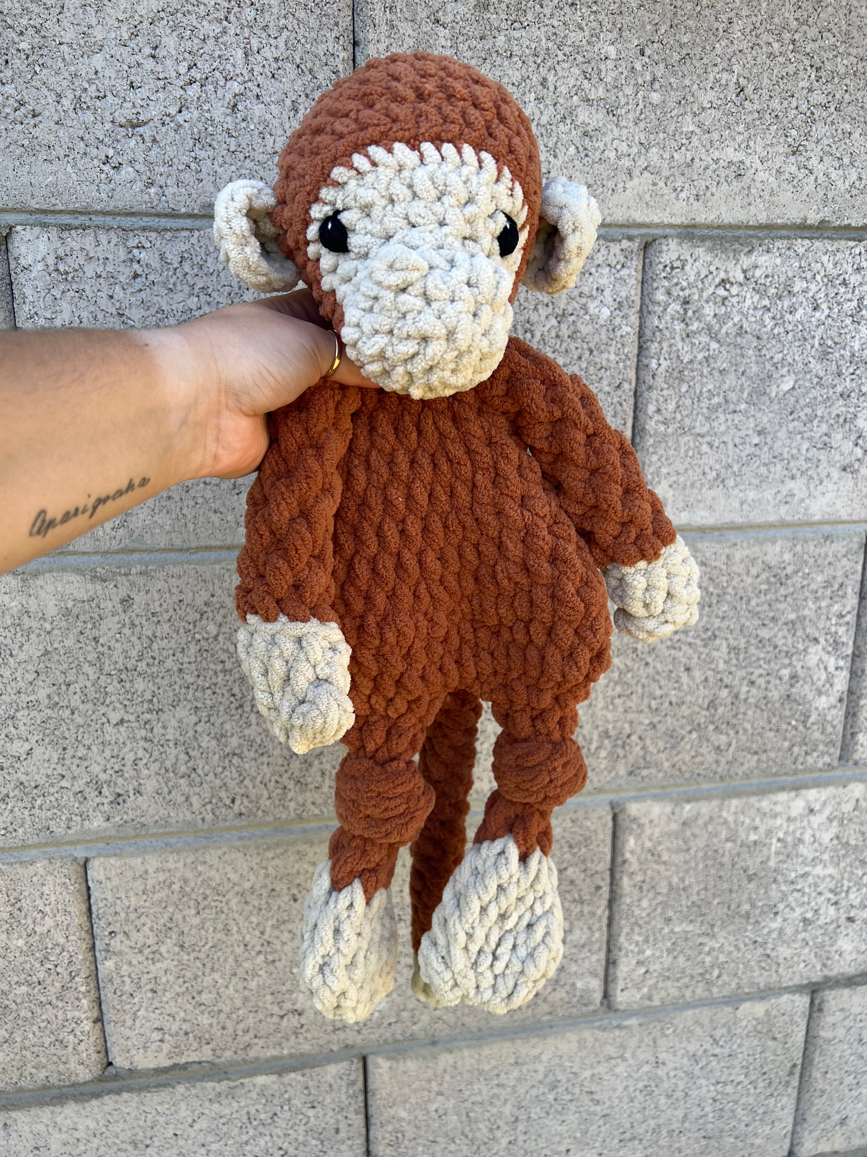 brown and tan monkey in front of grey brick wall