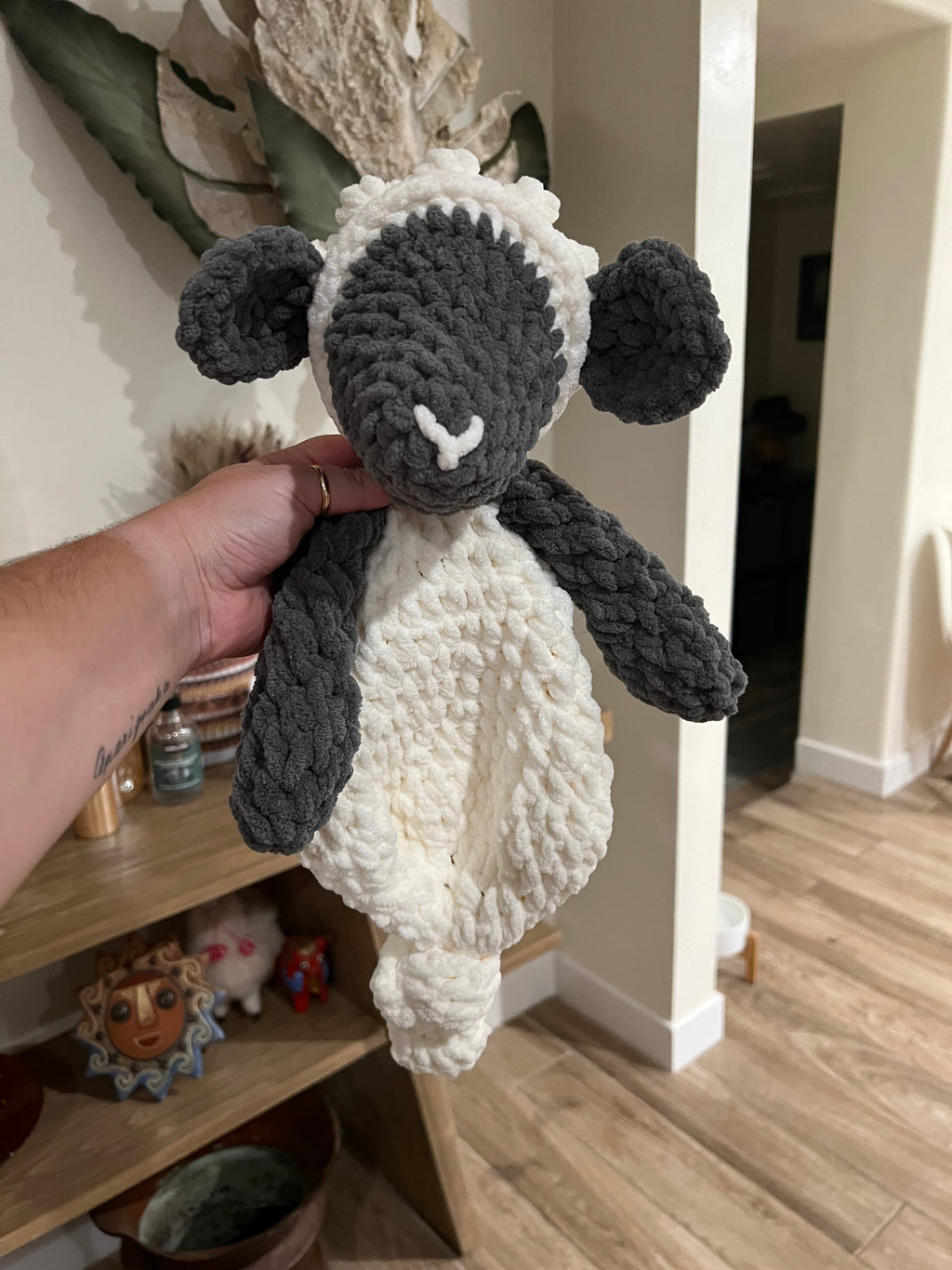 a crochet grey and white lamb with a blanket style body
