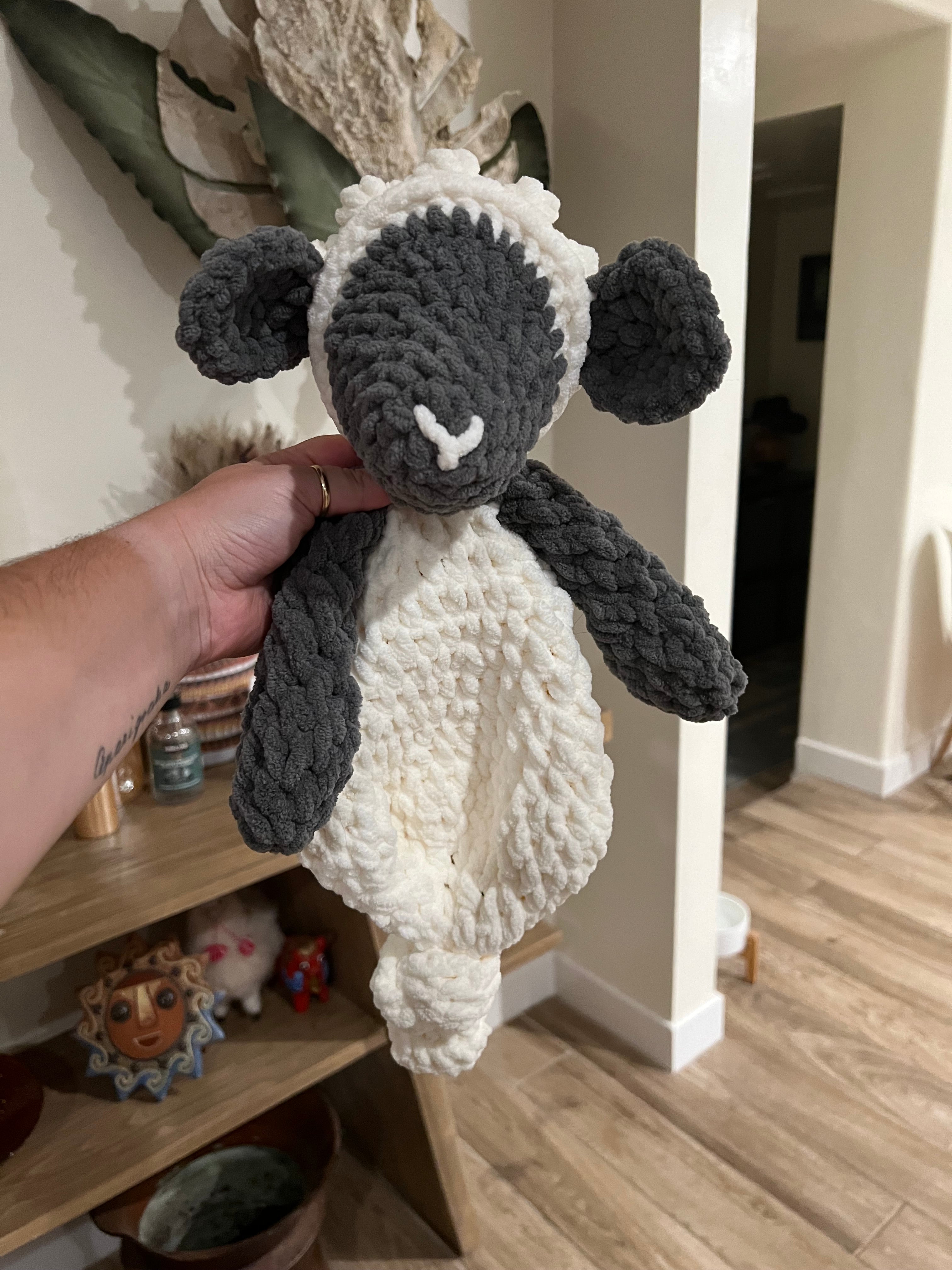 a crochet grey and white lamb with a blanket style body