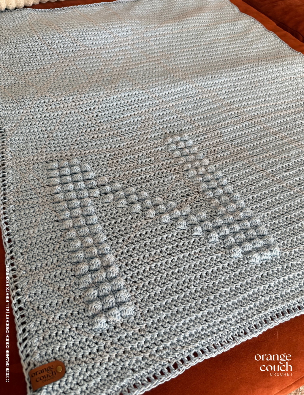 Blue N bobble crochet blanket on orange background