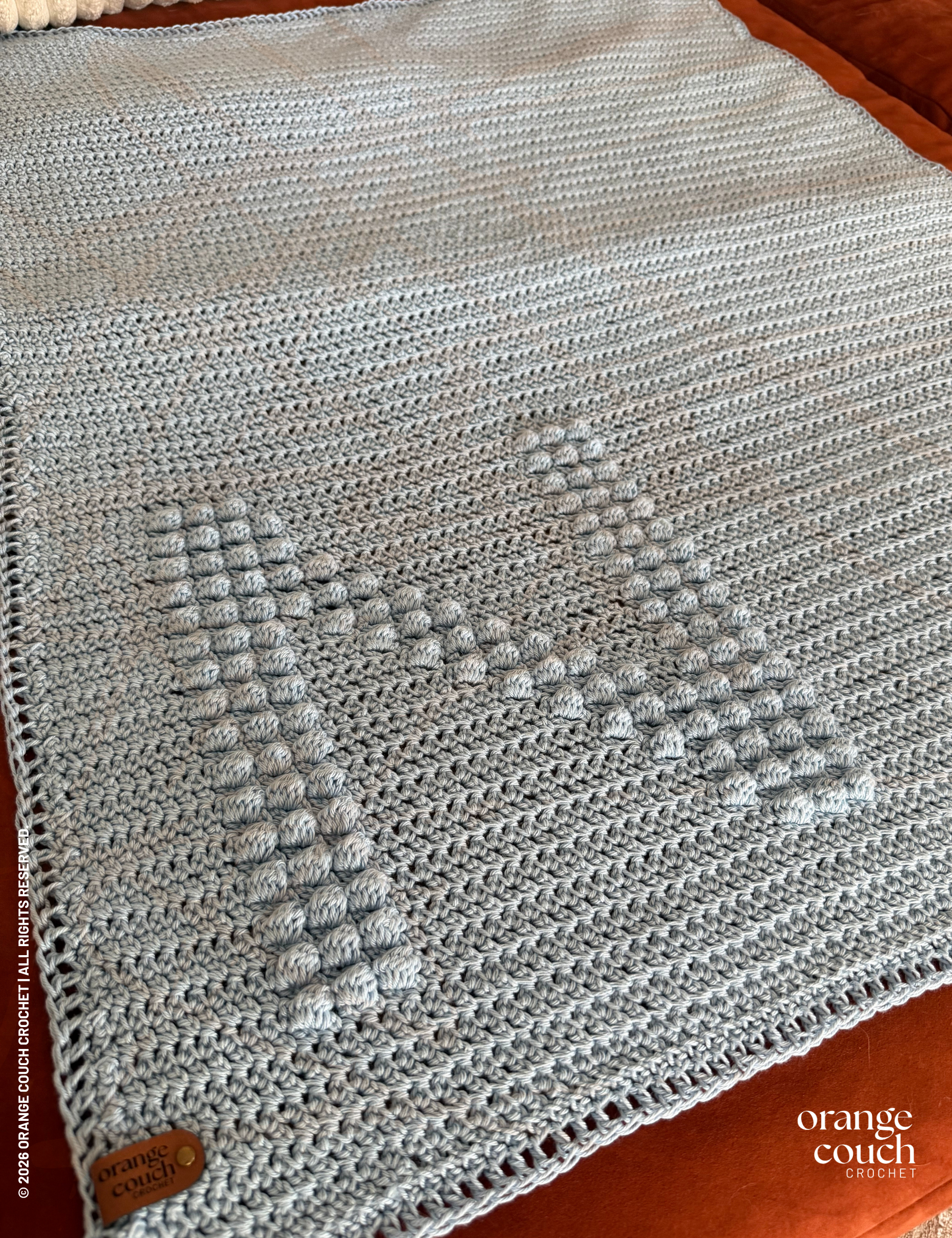 Blue N bobble crochet blanket on orange background
