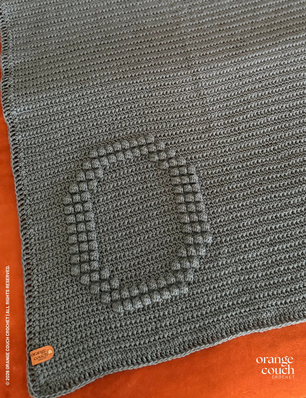 dark blue O bobble crochet blanket on orange background