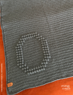 dark blue O bobble crochet blanket on orange background