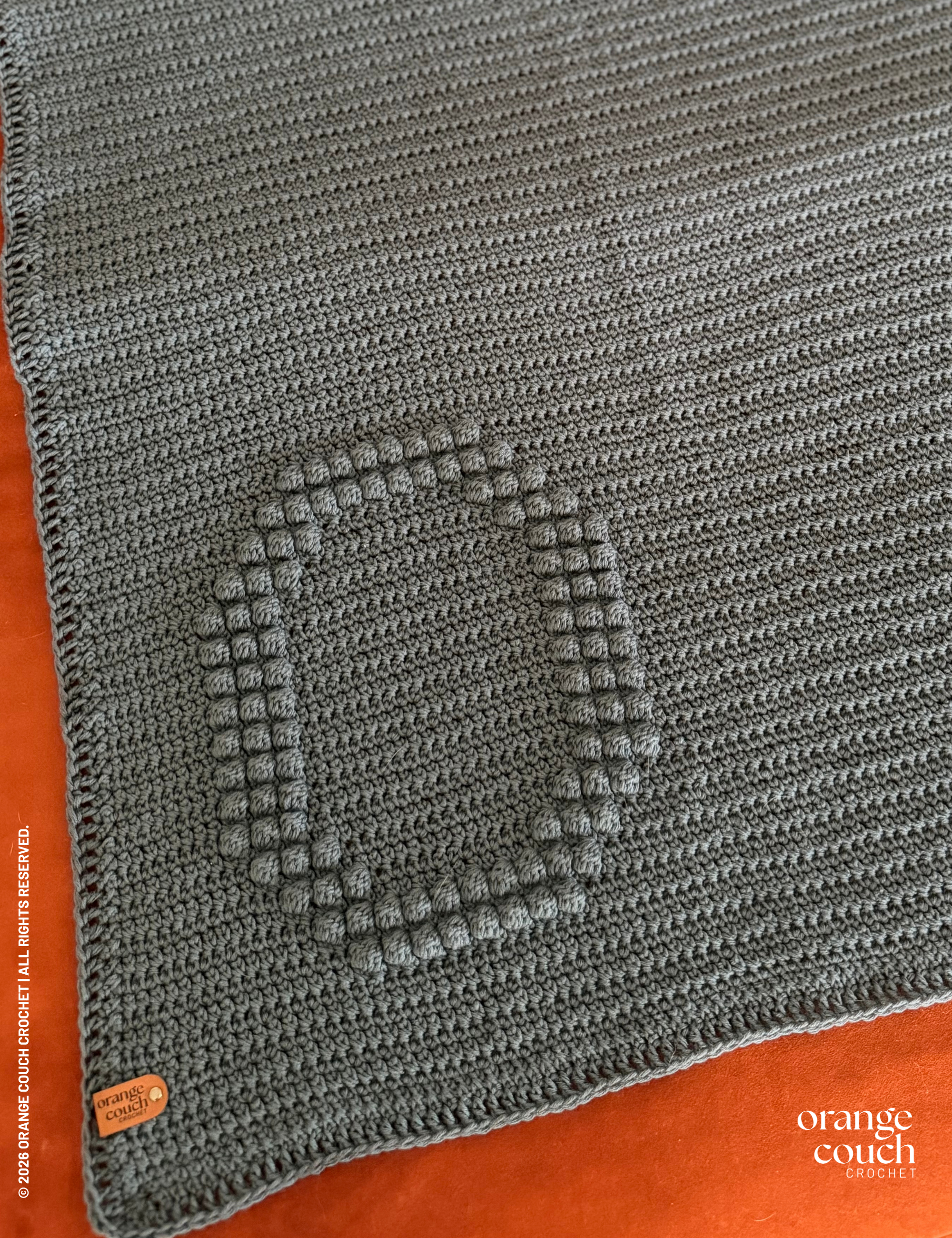 dark blue O bobble crochet blanket on orange background