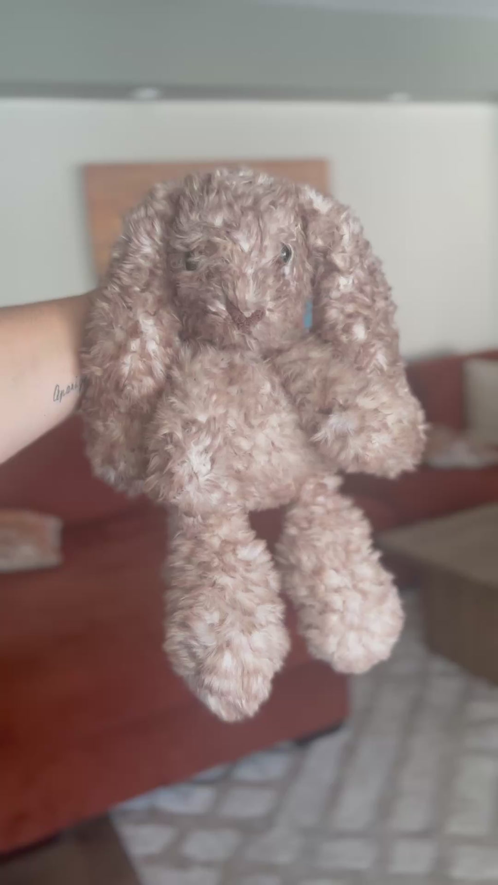 Crocheted bunny held by a hand with a blurred background