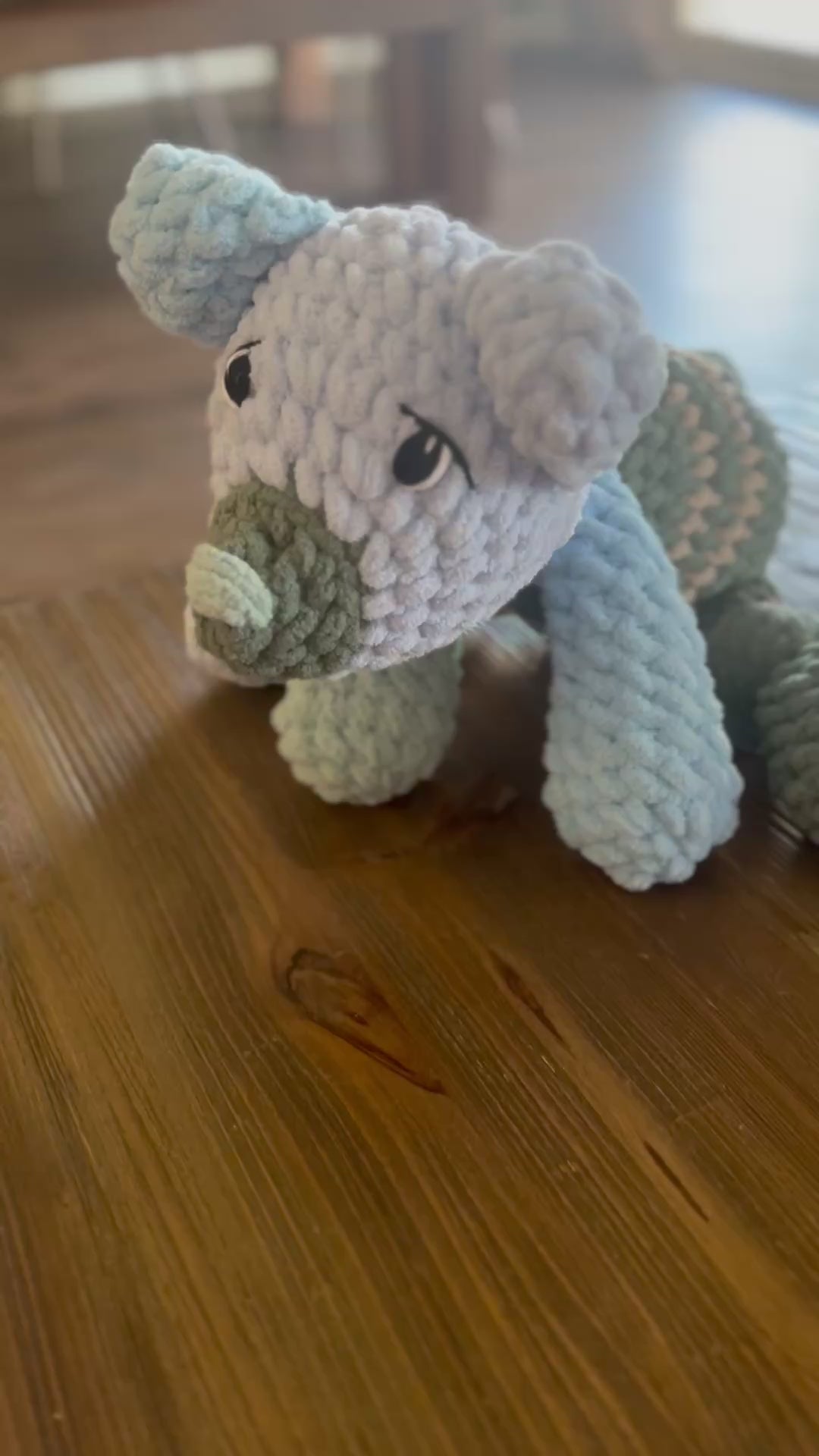video of patchwork bear in shades of blue, green, and tan on a wooden table