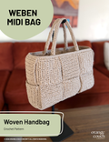 Beige crochet woven handbag on stand in front of blurred orange couch